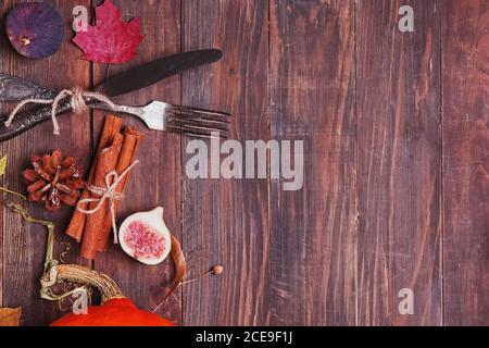 Autumn table setting with figs and dry leaves on wooden table Stock Photo
