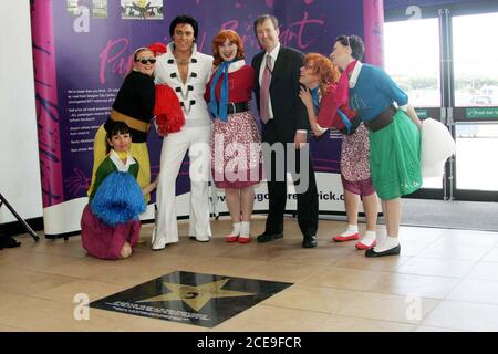 Glasgow Prestwick Airport Ayrshire in the United Kingdom is the only place visted by 'The King of Rock & Roll  Elvis Presley' Photo show his fans looking at the star to their hero on the concourse at the airport Photo shows Elvis Presley ( aka Gordon Hendricks winner of ITV Stars In their Eyes 2005 ) with Mark Rodwell Chief  Executive of Glasgow Prestwick Stock Photo