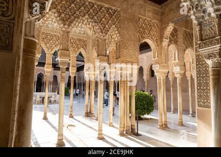 Tourists wearing masks visiting the Patio de los Leones of the Alhambra in Granada. Stock Photo