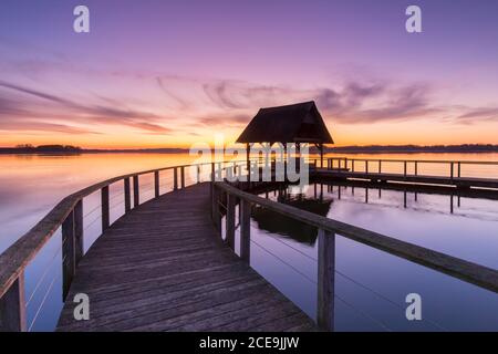 Wooden jetty on Lake Hemmelsdorf / Hemmelsdorfer See at sunrise in spring near Lübeck, Schleswig-Holstein, Germany Stock Photo