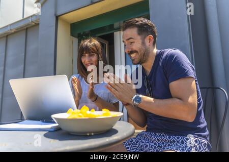 Couple clapping while looking something on the laptop Stock Photo