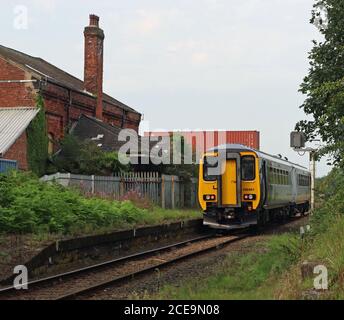 A Northern train passes through the closed station, Midge Hall near Leyland in Lancashire could this station be reopened to reverse a Beeching cut? Stock Photo