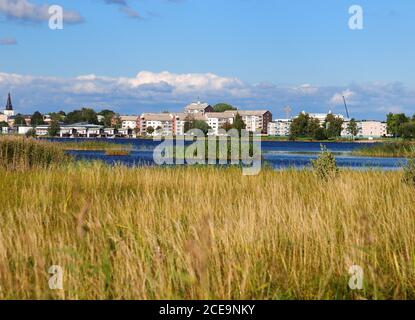 View From Grassland At Mariebergskogen To Klaralven River On A Sunny Summer Day With Some Clouds In The Sky Stock Photo