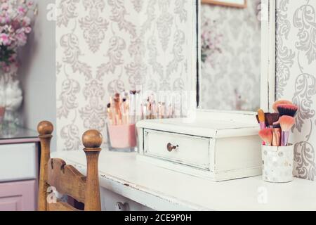 female makeup table with makeup including brushes and mirror. pink colors, girl design Stock Photo