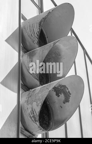 Monochrome shot of three metal pipes of an industrial aeration on the putside of a factory Stock Photo