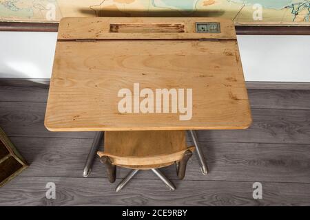 Empty desks at school classroom with world map. Stock Photo
