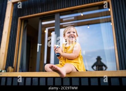 Small child playing outdoors, weekend away in container house in countryside. Stock Photo