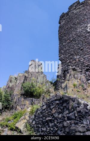Ruines of hazmburk castle on top of mountain peak of ceske stredohori range. View on the rocks and walls. Stock Photo