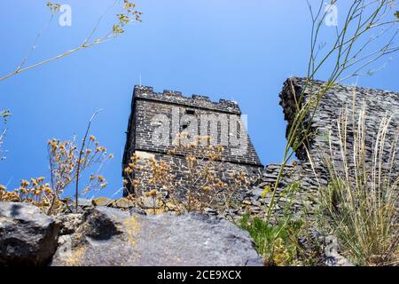 Ruines of hazmburk castle on top of mountain peak of ceske stredohori range. View on the white tower and walls. Stock Photo