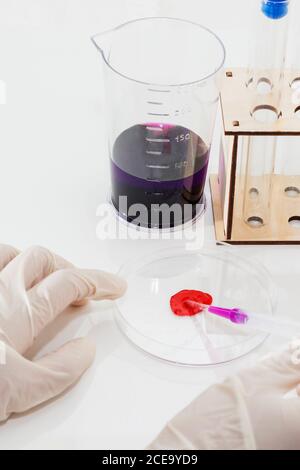 the medical doctor's hand works with a sample of blood, vial and flask. Stock Photo