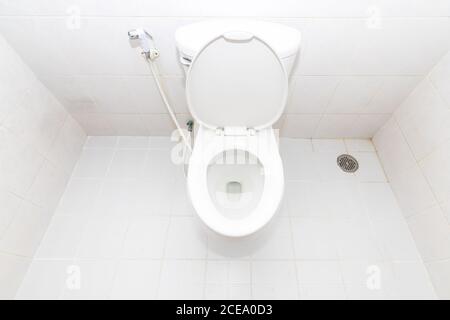 A clean modern toilet bowl and rising spray. Top view white toilet bowl in a bathroom. Stock Photo