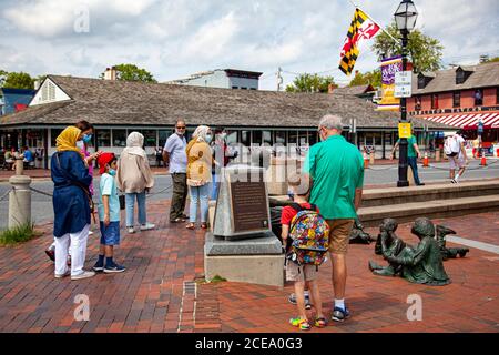 Annapolis, MD 08/21/2020: View of people around Kunta Kinte-Alex Haley memorial in historic dock of Annapolis. A caucasian man and his grandson as wel Stock Photo