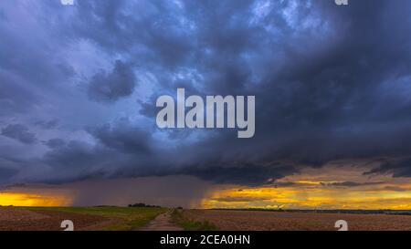Supercell storm clouds with wall cloud and intense rain Stock Photo
