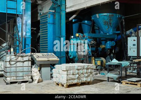 semi-dark interior of the woodworking workshop with equipment and packaging boards and planks Stock Photo