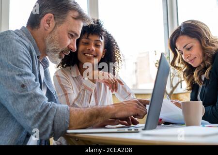 man using laptop near chatting colleagues Stock Photo