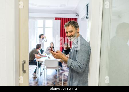 man browsing smartphone in office Stock Photo
