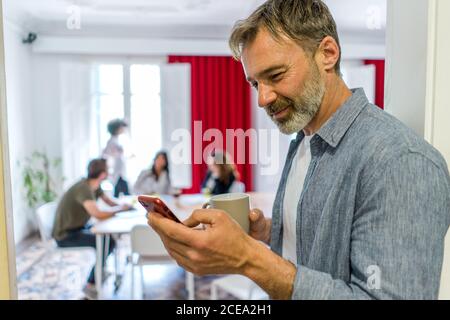 man browsing smartphone in office Stock Photo