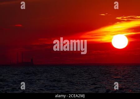 A spectacular Sunset over Chesapeake Bay, Maryland as photographed from eastern shore of Maryland. Image features the sun going down, red sky, reflect Stock Photo