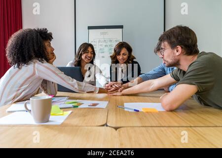 Group of workers crossed hands over meeting table Stock Photo