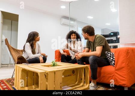 Young multiracial entrepreneurs discussing plans sitting in co working office Stock Photo