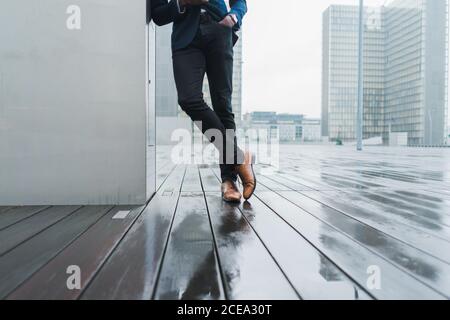 African-American businessman leaning on wall outdoors Stock Photo