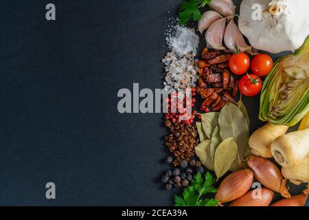 Bunch of assorted ripe vegetables and dried spices lying on gray background Stock Photo