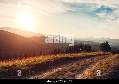 Beautiful sunset in Carpathian mountains. Summer ukrainian landscape. Dusky sky above wild nature with path Stock Photo