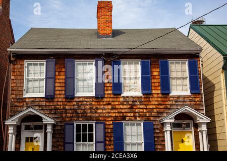 Annapolis, MD 08/21/2020: A vintage semidetached house with wooden tile exterior and dark blue window shutters in historic district of Annapoli, Maryl Stock Photo