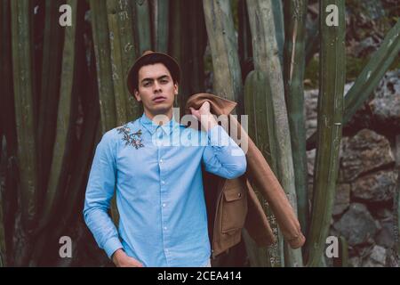 Thoughtful young handsome man at cactus Stock Photo