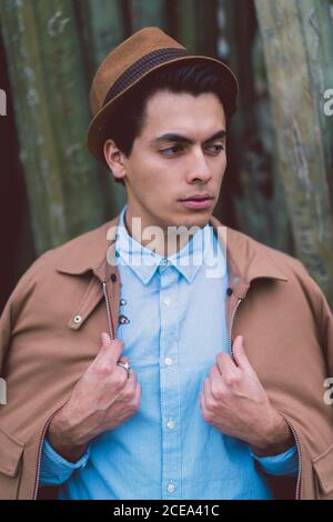 Thoughtful young handsome man at cactus Stock Photo