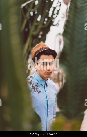 Thoughtful young handsome man at cactus Stock Photo