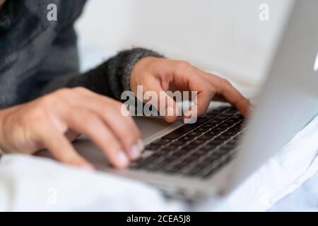 man chilling on bed with laptop Stock Photo