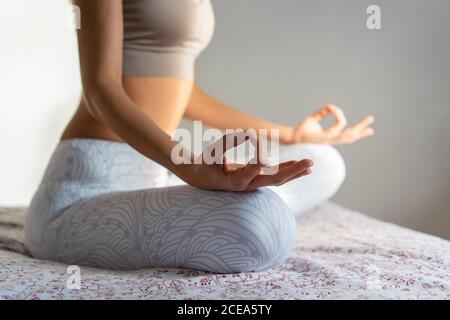 Young Woman meditating on bed Stock Photo