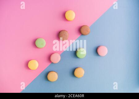 From above collection of bright delicious macarons on pink and blue background Stock Photo