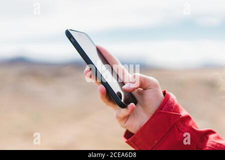Crop man standing with smartphone at geyser Stock Photo