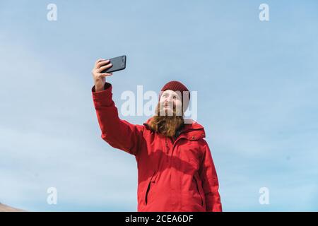 man standing with smartphone at geyser Stock Photo