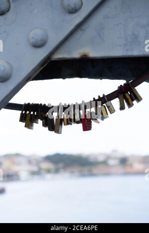 Set of different padlocks fixed on bridge above river in Porto, Portugal Stock Photo