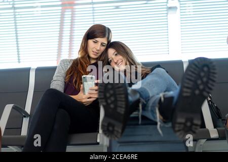 Young smiling Woman showing in smartphone to friend Stock Photo