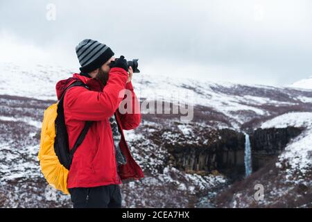 man using camera in snowy landscape Stock Photo