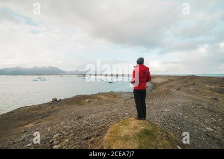 man standing by lake looking away Stock Photo