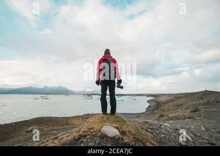 man standing by lake looking away Stock Photo