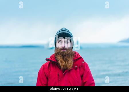 Attractive bearded man in warm clothes by water Stock Photo