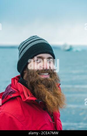 Attractive bearded man in warm clothes by water Stock Photo