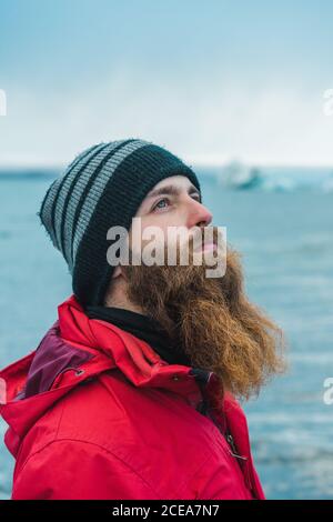 Attractive bearded man in warm clothes by water Stock Photo