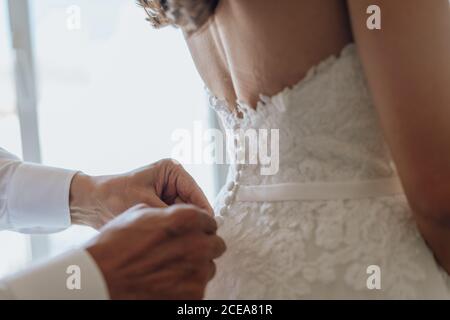 Crop man helping bride with corsage Stock Photo