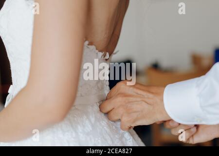 Crop man helping bride with corsage Stock Photo