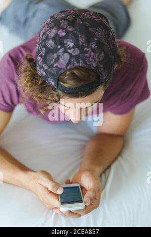 man using smartphone on bed Stock Photo