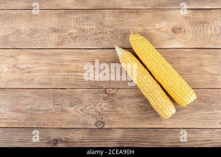 Peeled ears of corn on a wooden background. Stock Photo