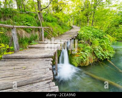 Wooden pathway path walkway trail National park Plitvice lakes in Croatia Europe water flowing waterflow waterfall scenic scenery Stock Photo