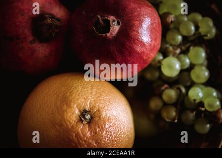 Composition of basket with oranges, grapes and pomegranates on table Stock Photo